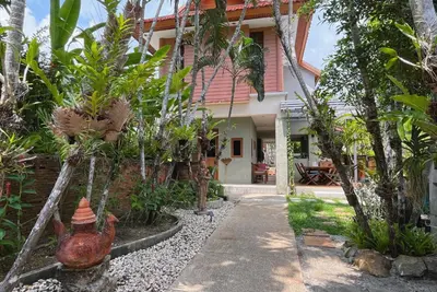 a house with a chicken statue in front of it at Baleeyan in Thalang