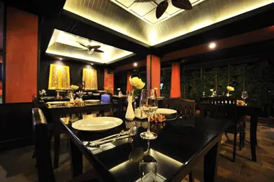a dining room with a table and chairs in a restaurant at Siralanna Hotel in Patong Beach