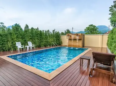 a swimming pool on a wooden deck with chairs at Aonang Glory Resort in Ao Nang Beach