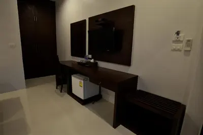 a room with a desk and a television in a room at Aonang Glory Resort in Ao Nang Beach