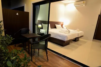 a bedroom with a bed and a table and chair at Aonang Glory Resort in Ao Nang Beach