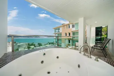 a bath tub on a balcony with a view of the ocean at Private sea view apartment with jacuzzi at Baycliff in Patong Beach