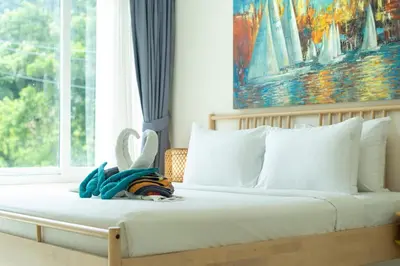 a bedroom with a bed with white pillows and a window at Private sea view apartment with jacuzzi at Baycliff in Patong Beach