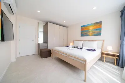 a bedroom with a bed and a painting on the wall at Private sea view apartment with jacuzzi at Baycliff in Patong Beach