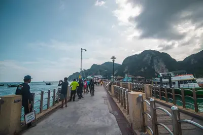 a group of people walking on a pier near the water at Phi Phi Sunset Bay Resort in Phi Phi Don