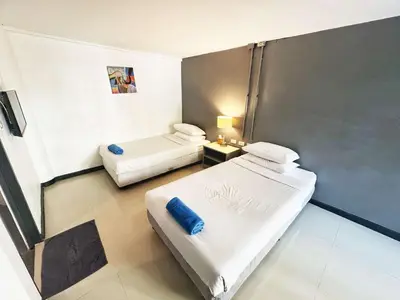 a small room with two beds and a table at Phi Phi Inn in Phi Phi Don