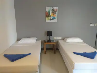 two beds in a room with blue pillows on them at Phi Phi Inn in Phi Phi Don