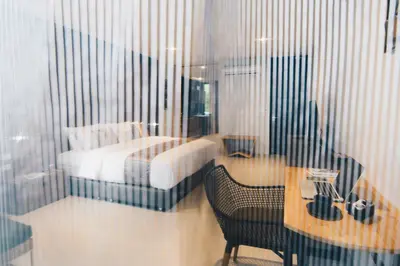 a bedroom with a bed and a desk and a table with a chair at Searocco Phuket in Patong Beach