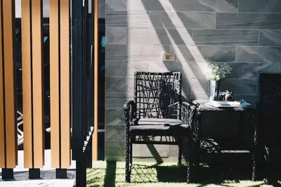 a black chair sitting next to a table on a building at Searocco Phuket in Patong Beach