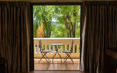 a balcony with a table and chairs in front of a window at Park 38 Hotel - SHA Plus in Phuket Town