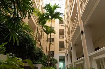 a hallway with palm trees in a building at Park 38 Hotel - SHA Plus in Phuket Town