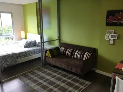 a living room with a couch and a bed at D-condo mine in Kathu