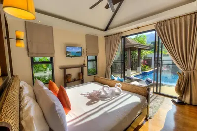a living room with a bed with two swans on it at Tulip Pool Villa Luxurious Villa Escape Awaits in Nai Harn Beach