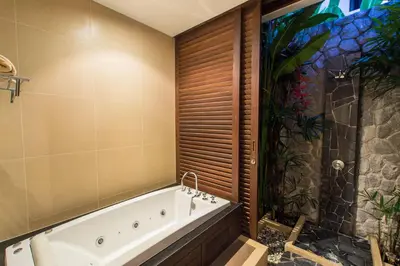 a bathroom with a bath tub and a shower at Tulip Pool Villa Luxurious Villa Escape Awaits in Nai Harn Beach