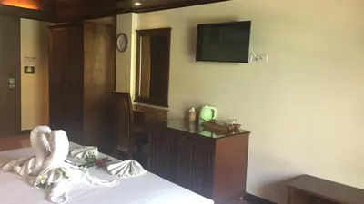 a hotel room with a bed with a tv on the wall at JJ Residence in Phi Phi Don