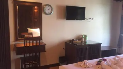 a bedroom with a clock on the wall and a bed at JJ Residence in Phi Phi Don