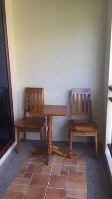 two wooden chairs and a table and two benches at JJ Residence in Phi Phi Don