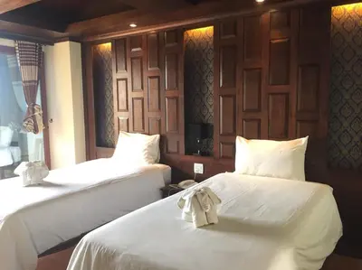 a room with two beds with white sheets and bows at JJ Residence in Phi Phi Don