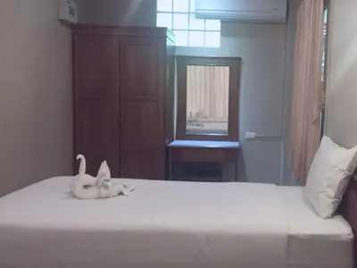 a white cat laying on top of a bed at JJ Bungalow in Phi Phi Don