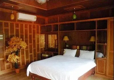 a bedroom with a white bed and wooden walls at JJ Bungalow in Phi Phi Don