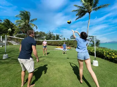 a group of people playing volley ball on a field at Naam Sawan in Ban Pa Khlok