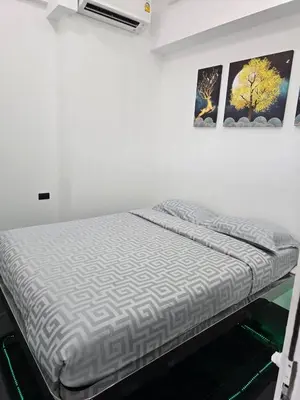 a bed in a room with a picture on the wall at PATONG TOWER SEA VIEW 3 BEDROOMs in Patong Beach