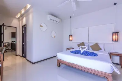 a bedroom with a large white bed and a table at VILLA BUTON Private Pool Nai Harn beach in Nai Harn Beach