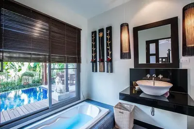a bathroom with a tub and a sink and a pool at VILLA BUTON Private Pool Nai Harn beach in Nai Harn Beach