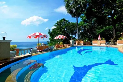 a large swimming pool with the ocean in the background at Baan Karon Hill Phuket Resort in Karon Beach