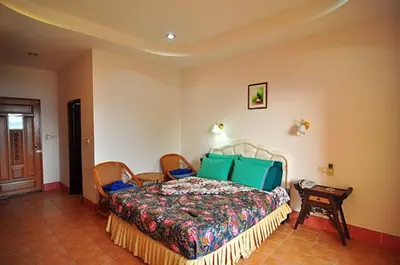 a bedroom with a large bed with green pillows at Baan Karon Hill Phuket Resort in Karon Beach