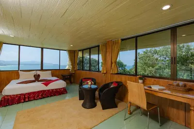a bedroom in a house with a bed and a desk at Baan Karon Hill Phuket Resort in Karon Beach