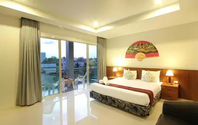 a hotel room with a bed and a balcony at Choophorn House in Kata Beach