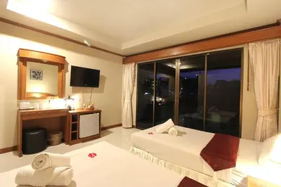 a hotel room with a bed and a large window at Choophorn House in Kata Beach
