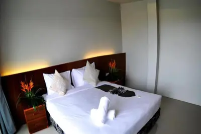 a bedroom with a large white bed with two white towels at Choophorn House in Kata Beach