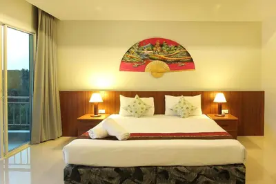 a bedroom with a large bed and a large window at Choophorn House in Kata Beach