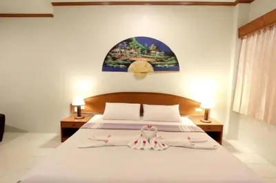 a bedroom with a bed with two towels on it at Choophorn House in Kata Beach