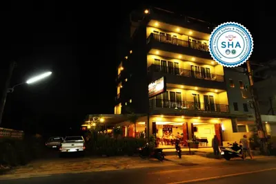 a building with a sign in front of it at night at Choophorn House in Kata Beach