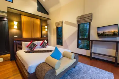 a bedroom with a bed and a couch and a tv at Hidden Pool Villa A Hidden Haven Just For You in Rawai Beach