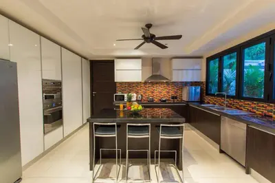 a kitchen with a black counter and a ceiling fan at Hidden Pool Villa A Hidden Haven Just For You in Rawai Beach