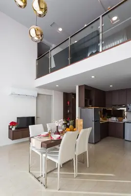 a kitchen and dining room with a table and chairs at The Aristo by Holy Cow, 2-BR loft, 90 m2, pool view in Surin Beach