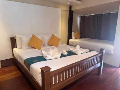 a bedroom with two beds with yellow and white pillows at Chunut House Resort in Phi Phi Don
