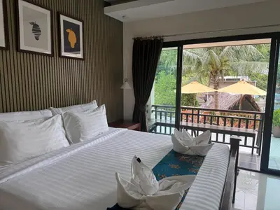 a bedroom with a bed with a view of a patio at Chunut House Resort in Phi Phi Don