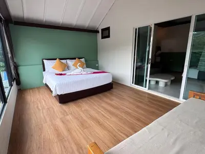 a bedroom with a bed and a large window at Chunut House Resort in Phi Phi Don