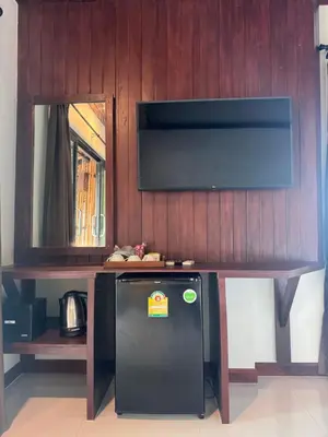 a small refrigerator under a table with a television at Chunut House Resort in Phi Phi Don
