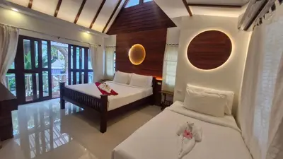 a bedroom with two beds and a window at Chunut House Resort in Phi Phi Don