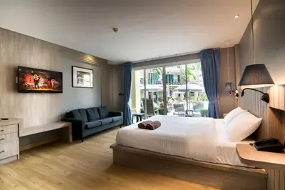 a hotel room with a bed and a couch at Baan Karon Resort in Karon Beach