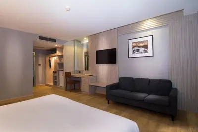 a hotel room with a bed and a couch at Baan Karon Resort in Karon Beach