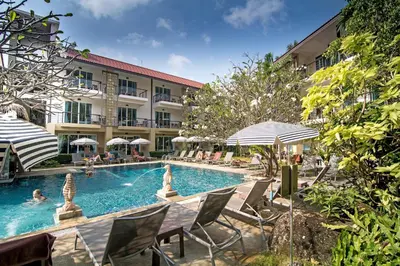 a pool at a hotel with chairs and umbrellas at Baan Karon Resort in Karon Beach