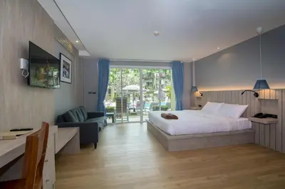 a bedroom with a bed and a couch and a chair at Baan Karon Resort in Karon Beach