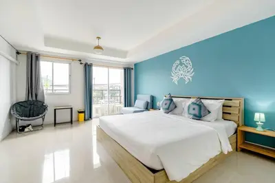 a bedroom with a large bed with blue walls at Turtle Rooms in Bang Tao Beach